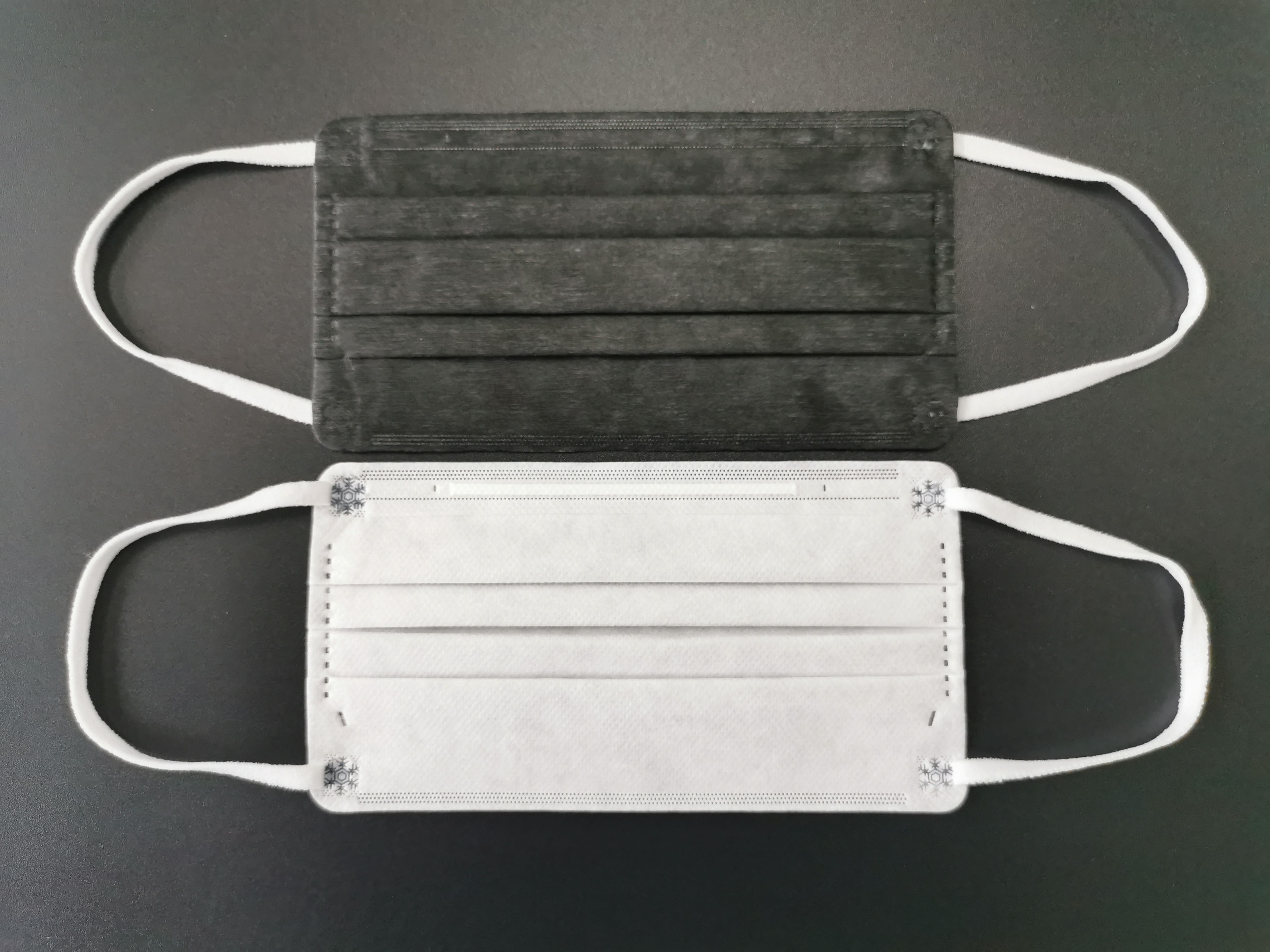 A professional evaluating different disposable face mask types for workplace compliance